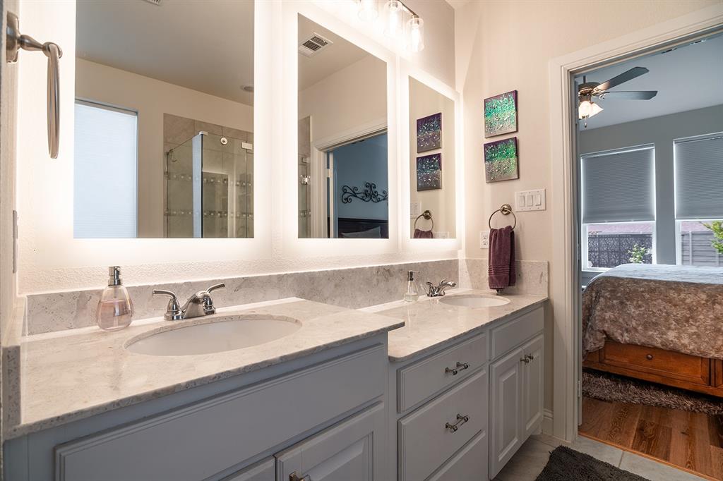 1213 Sea Island Road Aubrey, TX 76227 - Photo 28 of 36 Primary bathroom featuring dual sinks, one raised for convenience, and stunning mirrors with surrounding lighting—an eye-catching and functional design
