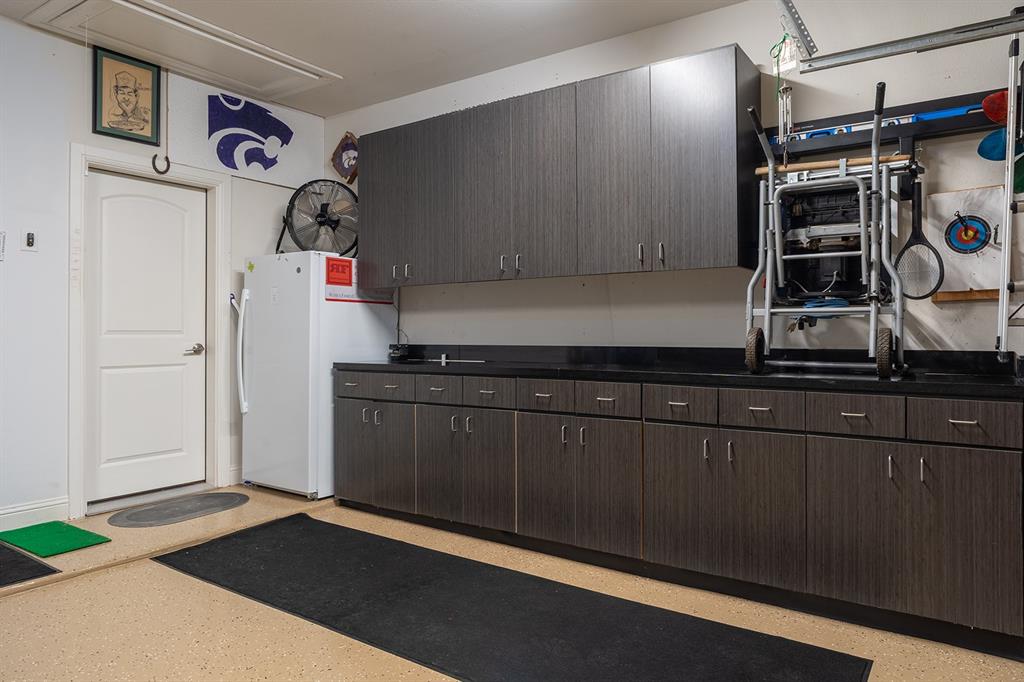 1213 Sea Island Road Aubrey, TX 76227 - Photo 31 of 36 Impressive garage workshop with durable epoxy flooring, 9’ ceilings, and built-in space ready for projects, tools, and serious work!