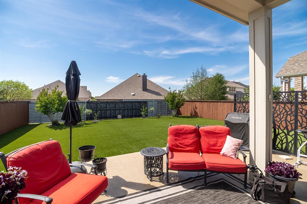 1213 Sea Island Road Aubrey, TX 76227 - Photo 32 of 36 Covered patio overlooking a low-maintenance turf backyard—perfect for relaxing, playing, and enjoying your own fun outdoor escape