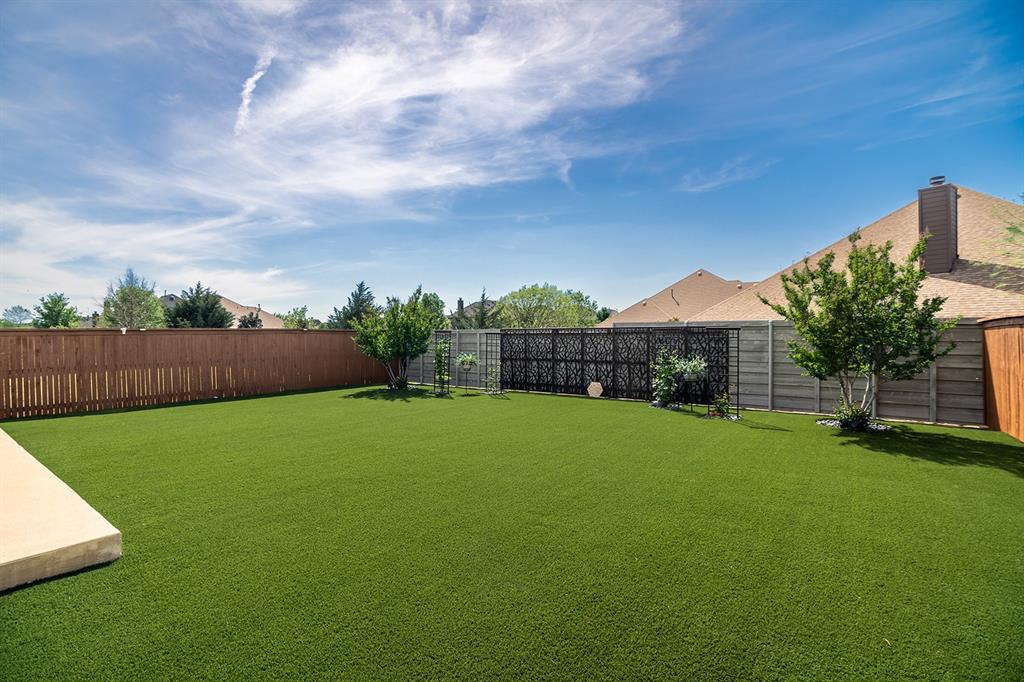 1213 Sea Island Road Aubrey, TX 76227 - Photo 34 of 36 Beautiful, professionally installed turf backyard offering a lush, green look year-round with low-maintenance ease