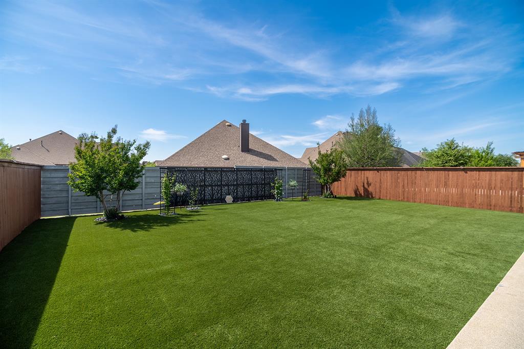 1213 Sea Island Road Aubrey, TX 76227 - Photo 35 of 36 Beautiful, professionally installed turf backyard offering a lush, green look year-round with low-maintenance ease
