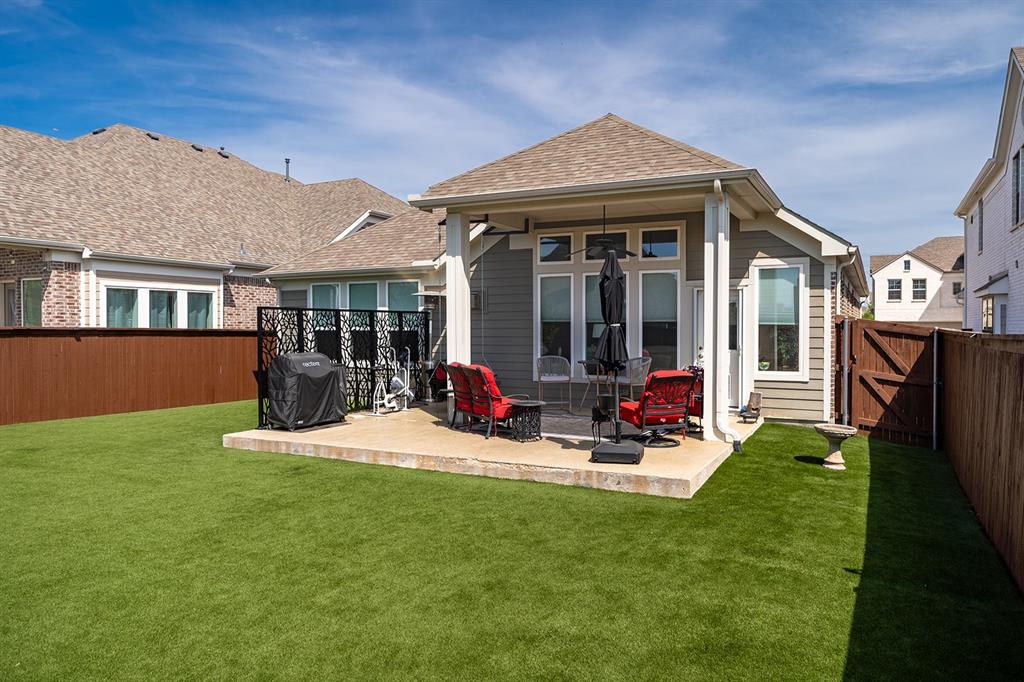 1213 Sea Island Road Aubrey, TX 76227 - Photo 36 of 36 Come home to your cozy retreat—covered patio and lush turf backyard perfect for relaxing, playing, and making memories.