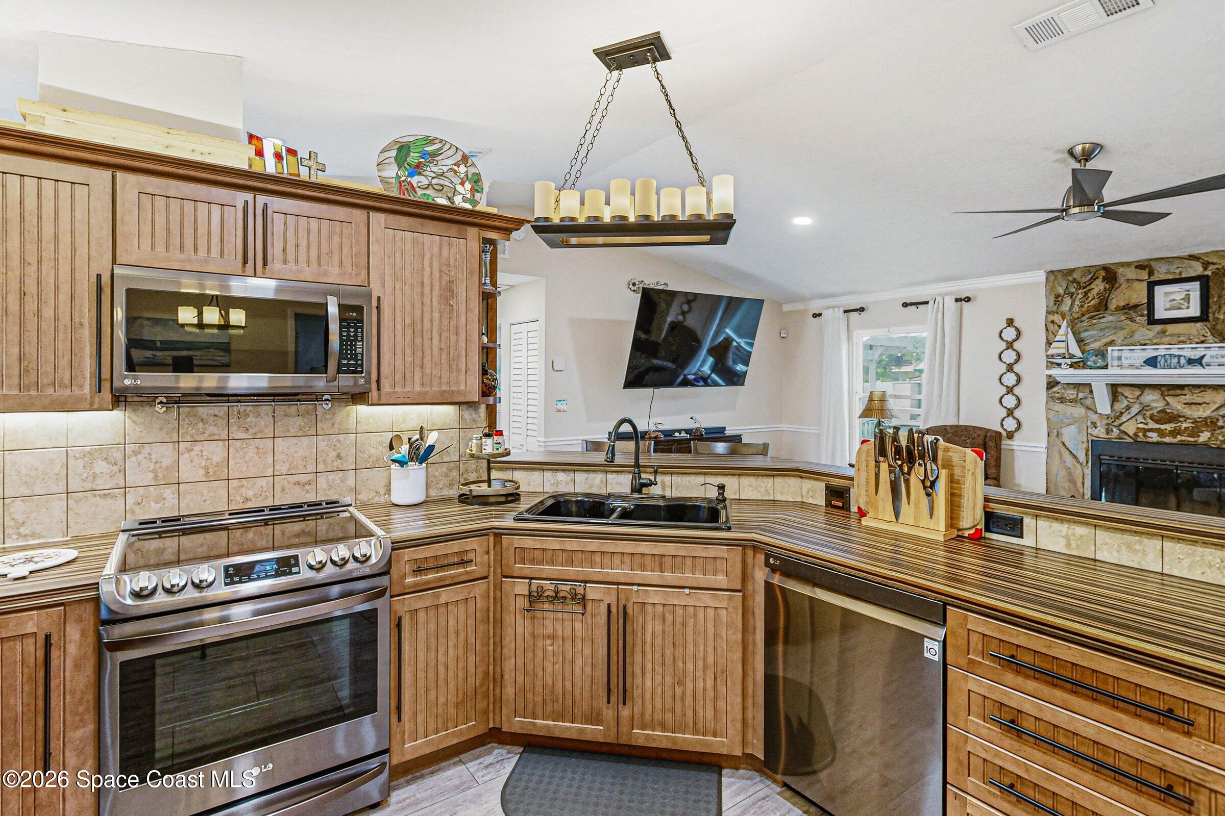 413 Orlov Road Northwest Palm Bay, FL 32907 - Photo 14 of 63 a kitchen with stainless steel appliances a stove sink microwave and cabinets