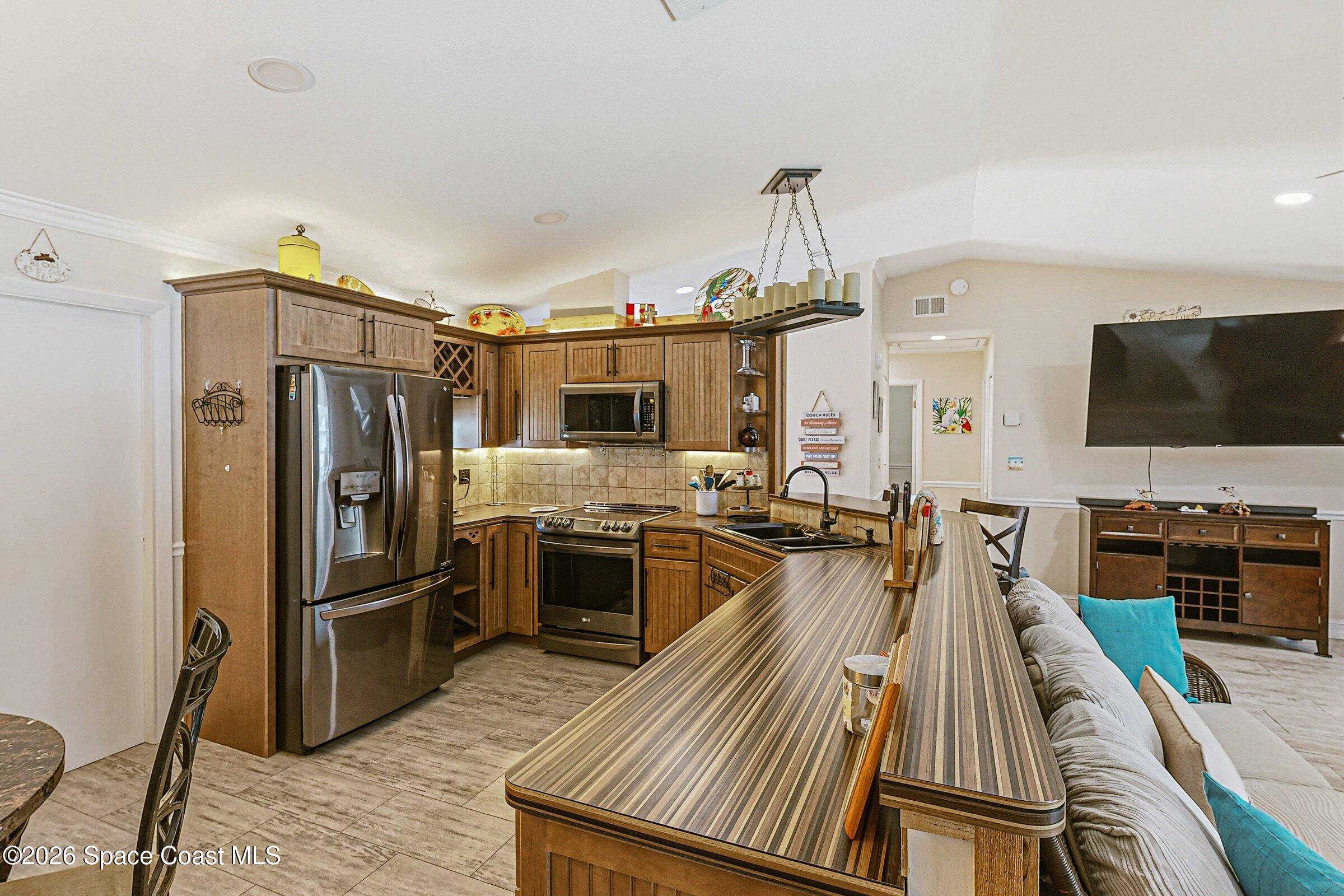 413 Orlov Road Northwest Palm Bay, FL 32907 - Photo 15 of 63 a kitchen with stainless steel appliances granite countertop a refrigerator stove and sink