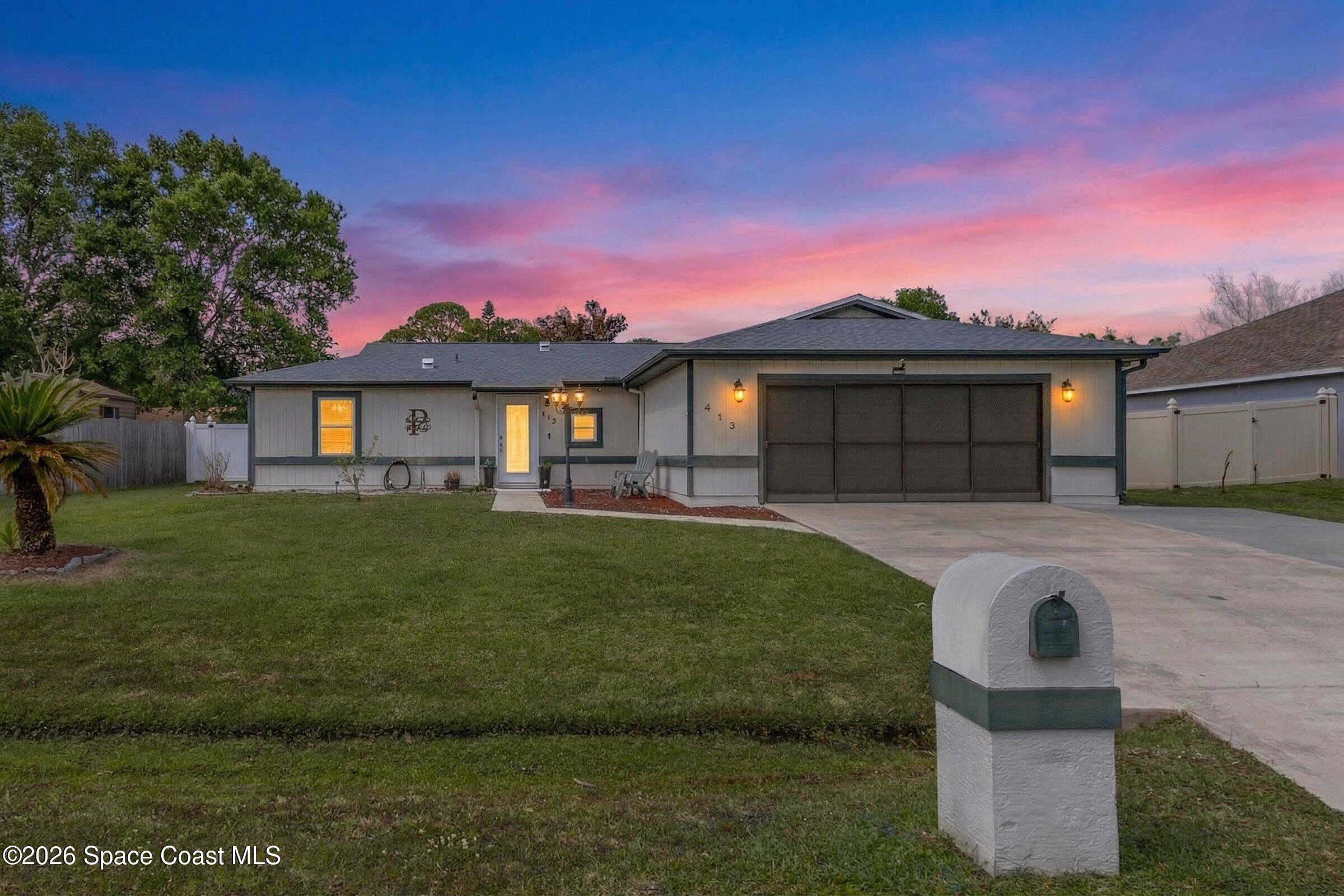 413 Orlov Road Northwest Palm Bay, FL 32907 - Photo 2 of 63 a front view of a house with a garden and yard