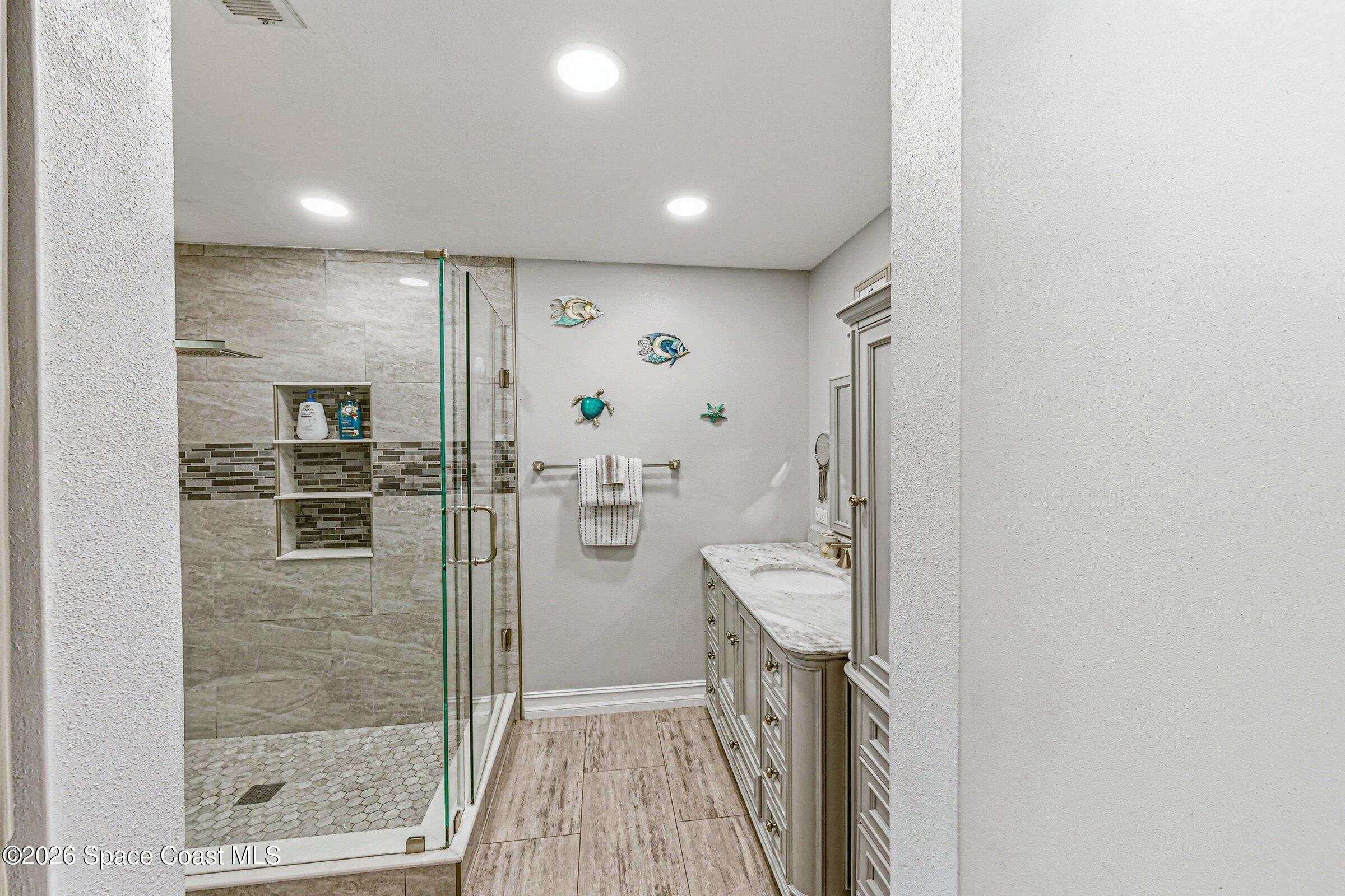 413 Orlov Road Northwest Palm Bay, FL 32907 - Photo 21 of 63 a bathroom with a glass shower door