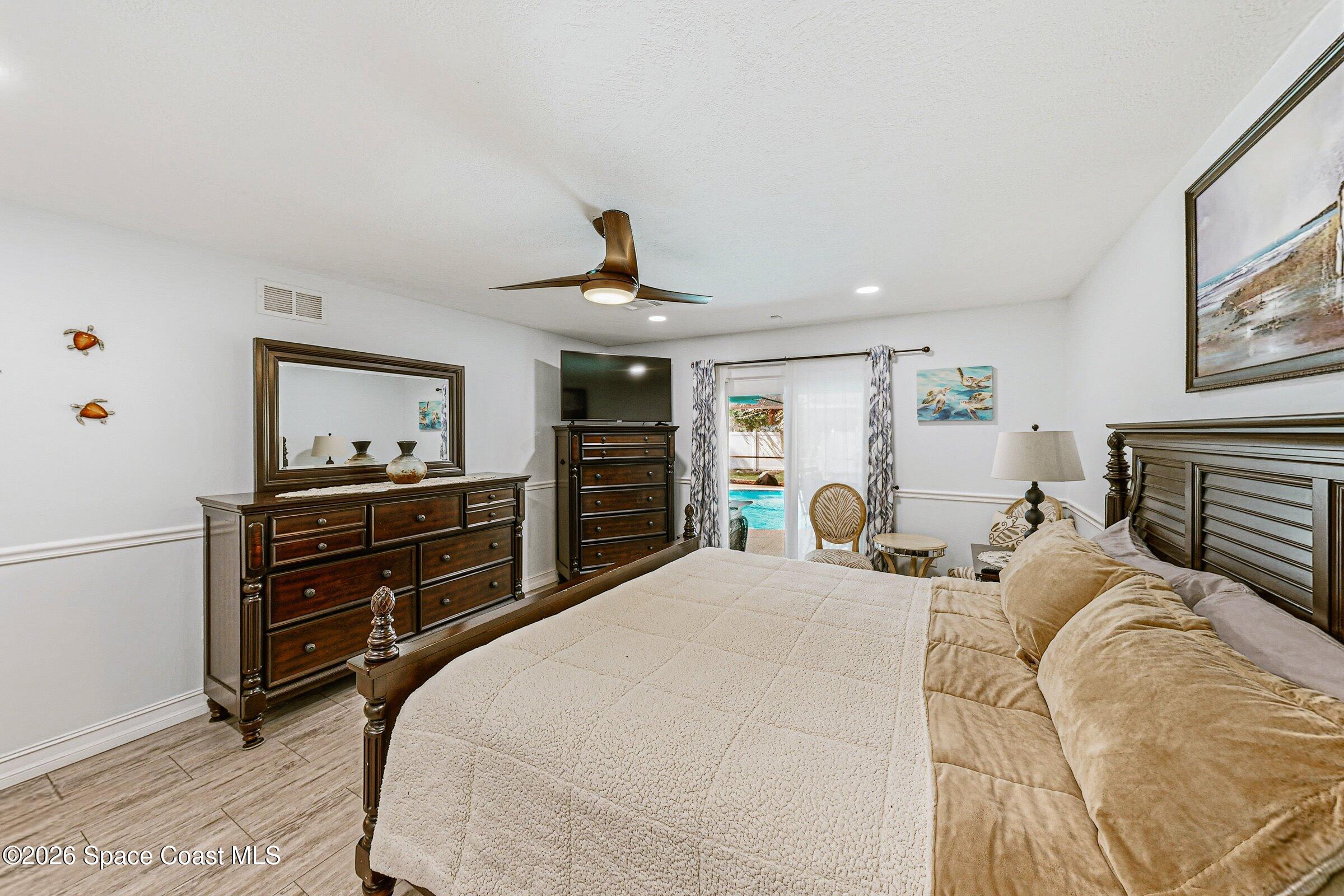 413 Orlov Road Northwest Palm Bay, FL 32907 - Photo 24 of 63 a bedroom with a bed and wooden floor