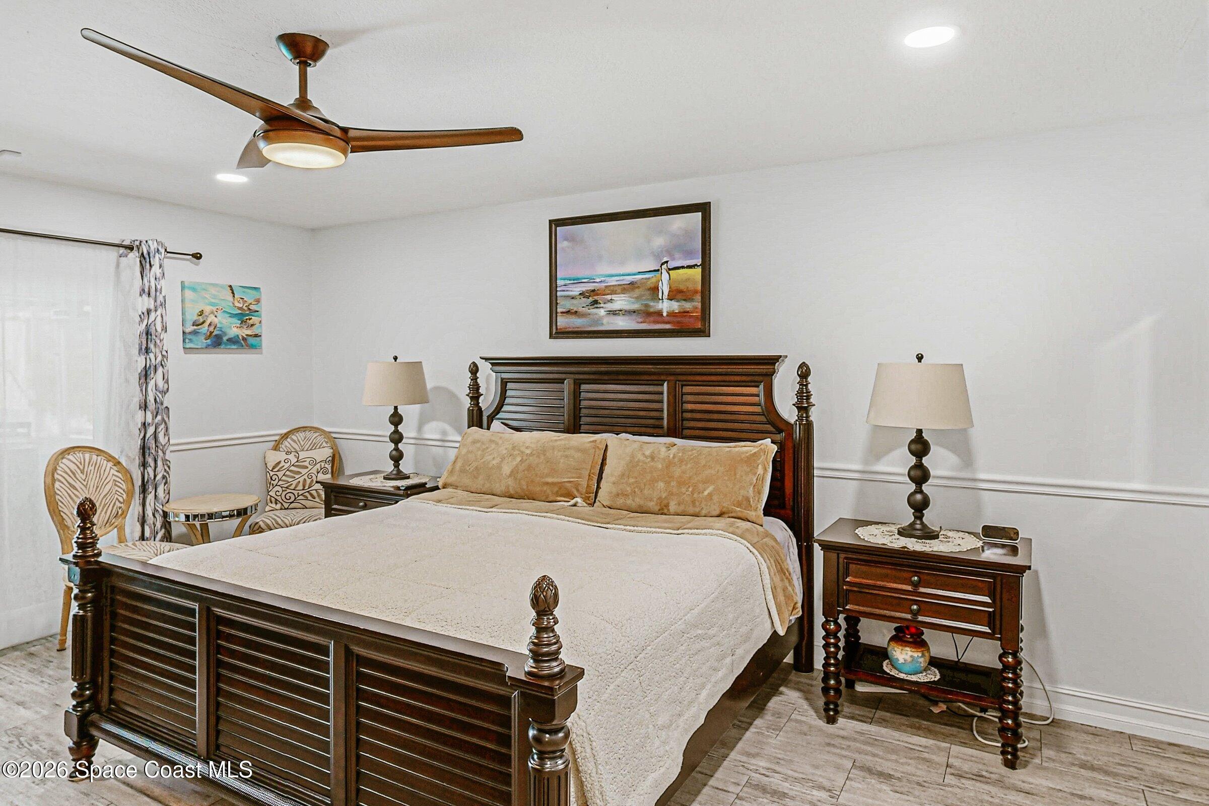 413 Orlov Road Northwest Palm Bay, FL 32907 - Photo 26 of 63 a bedroom with a bed and a chandelier