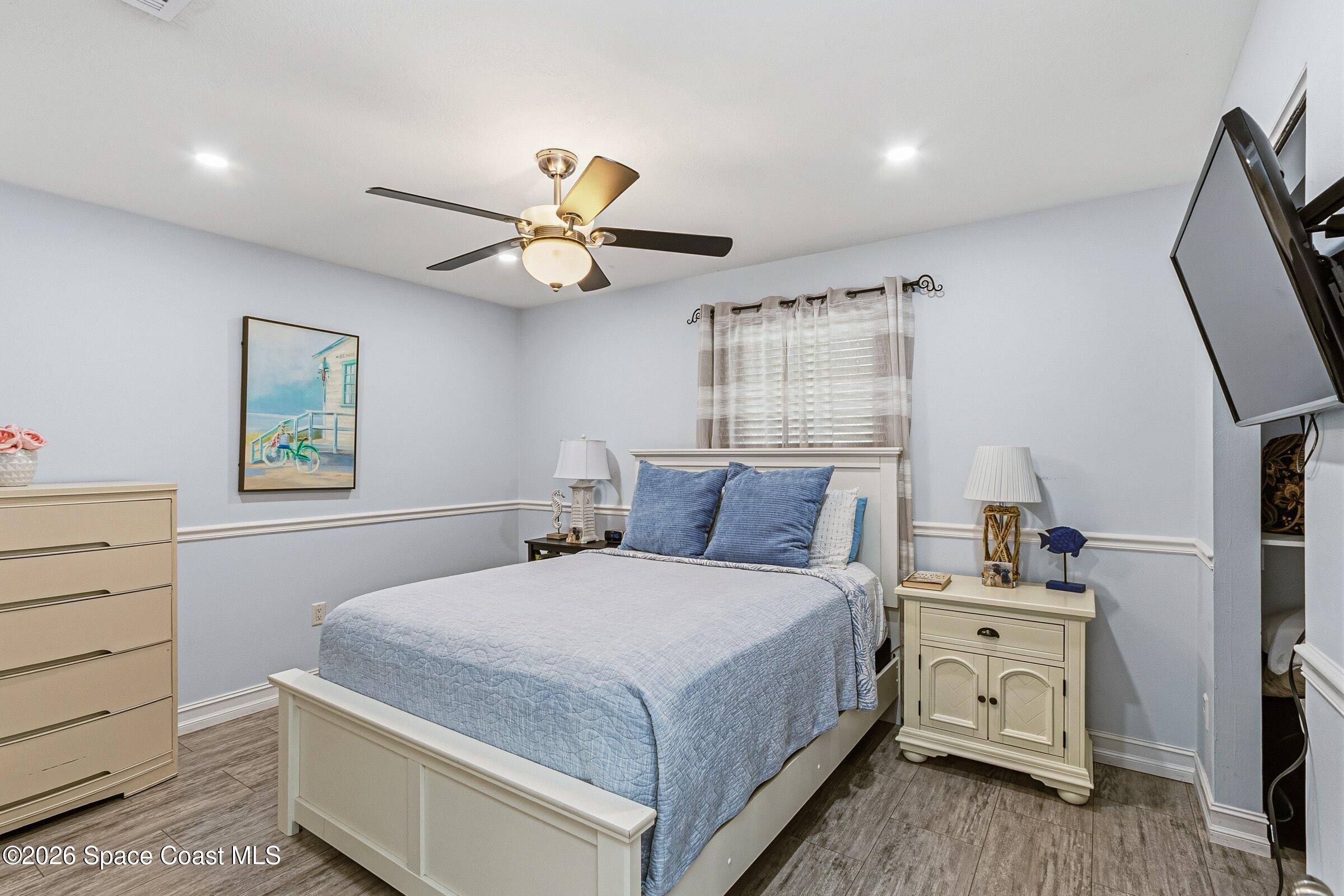 413 Orlov Road Northwest Palm Bay, FL 32907 - Photo 28 of 63 a bedroom with a bed and a chandelier