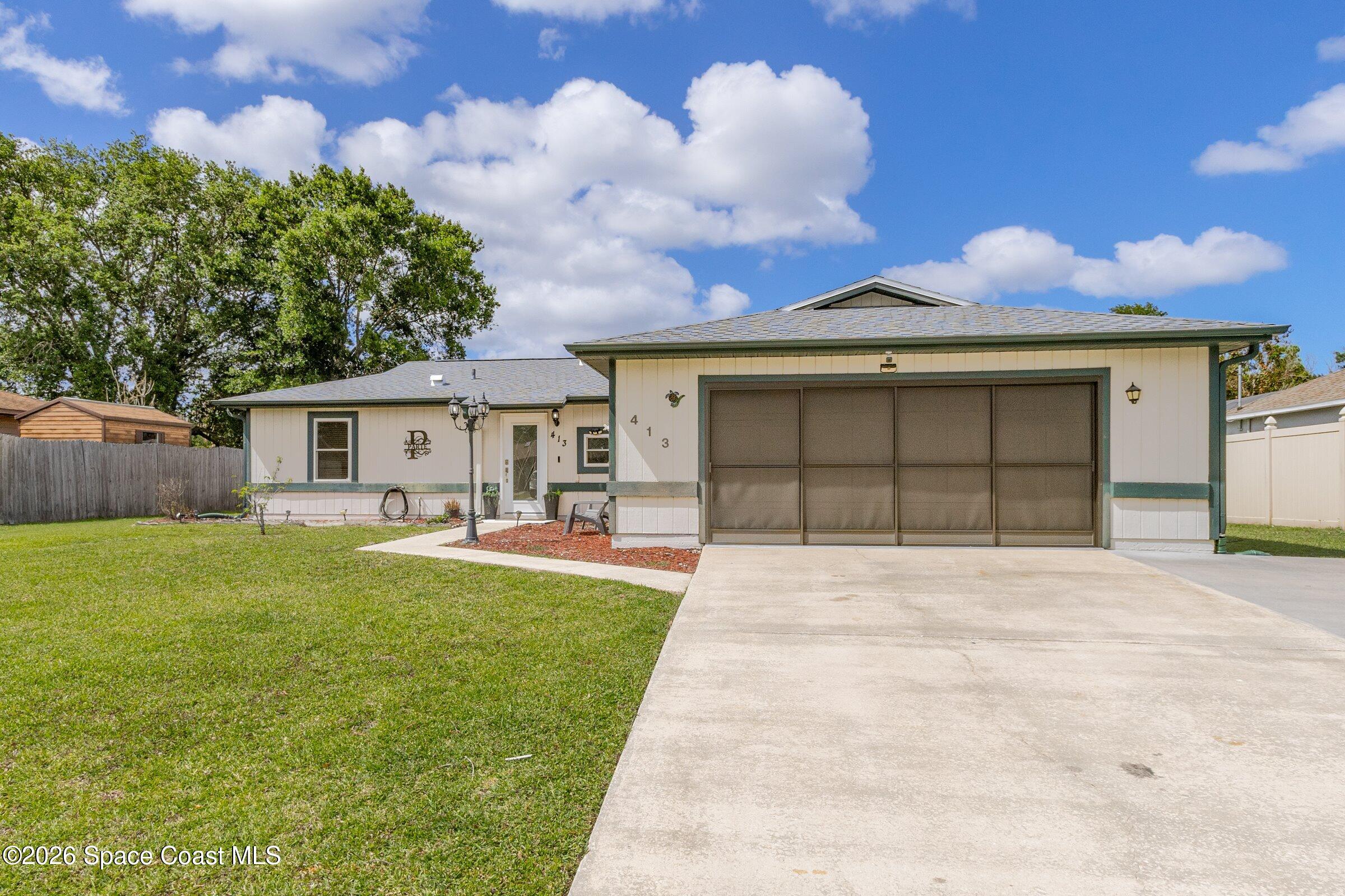 413 Orlov Road Northwest Palm Bay, FL 32907 - Photo 3 of 63 a front view of a house with a yard and garage