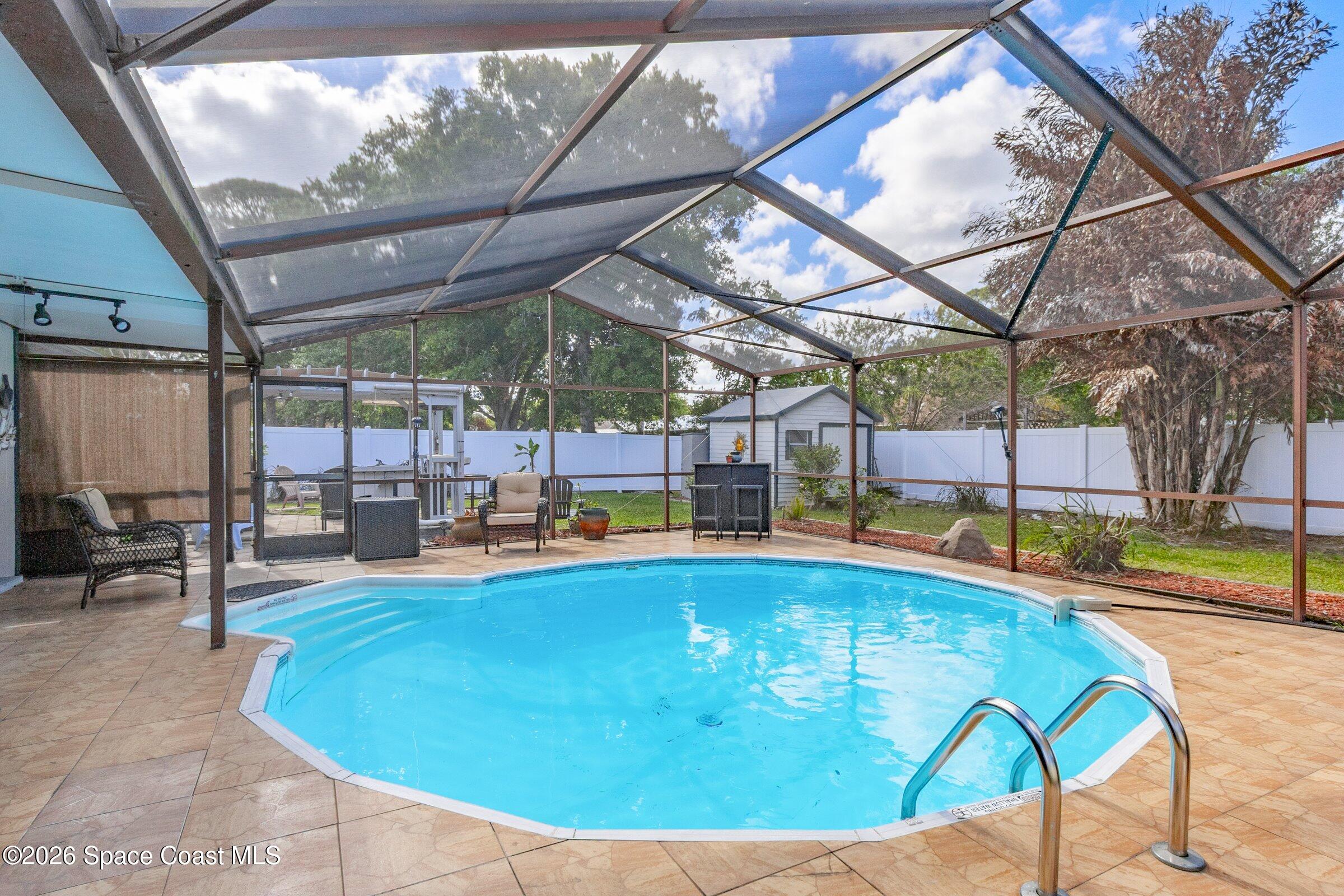 413 Orlov Road Northwest Palm Bay, FL 32907 - Photo 34 of 63 a view of a swimming pool with a patio