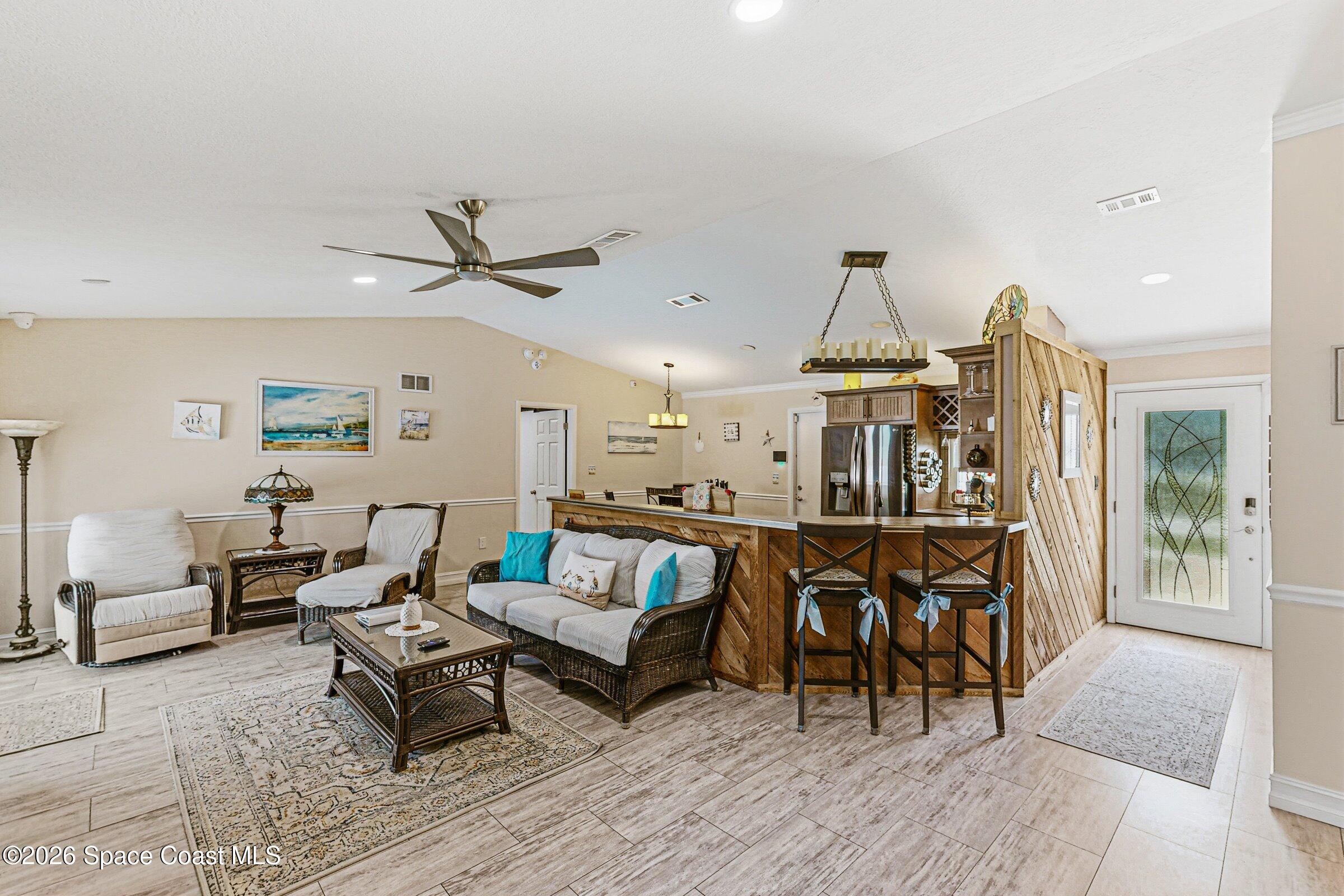 413 Orlov Road Northwest Palm Bay, FL 32907 - Photo 4 of 63 a living room with furniture a rug and a chandelier