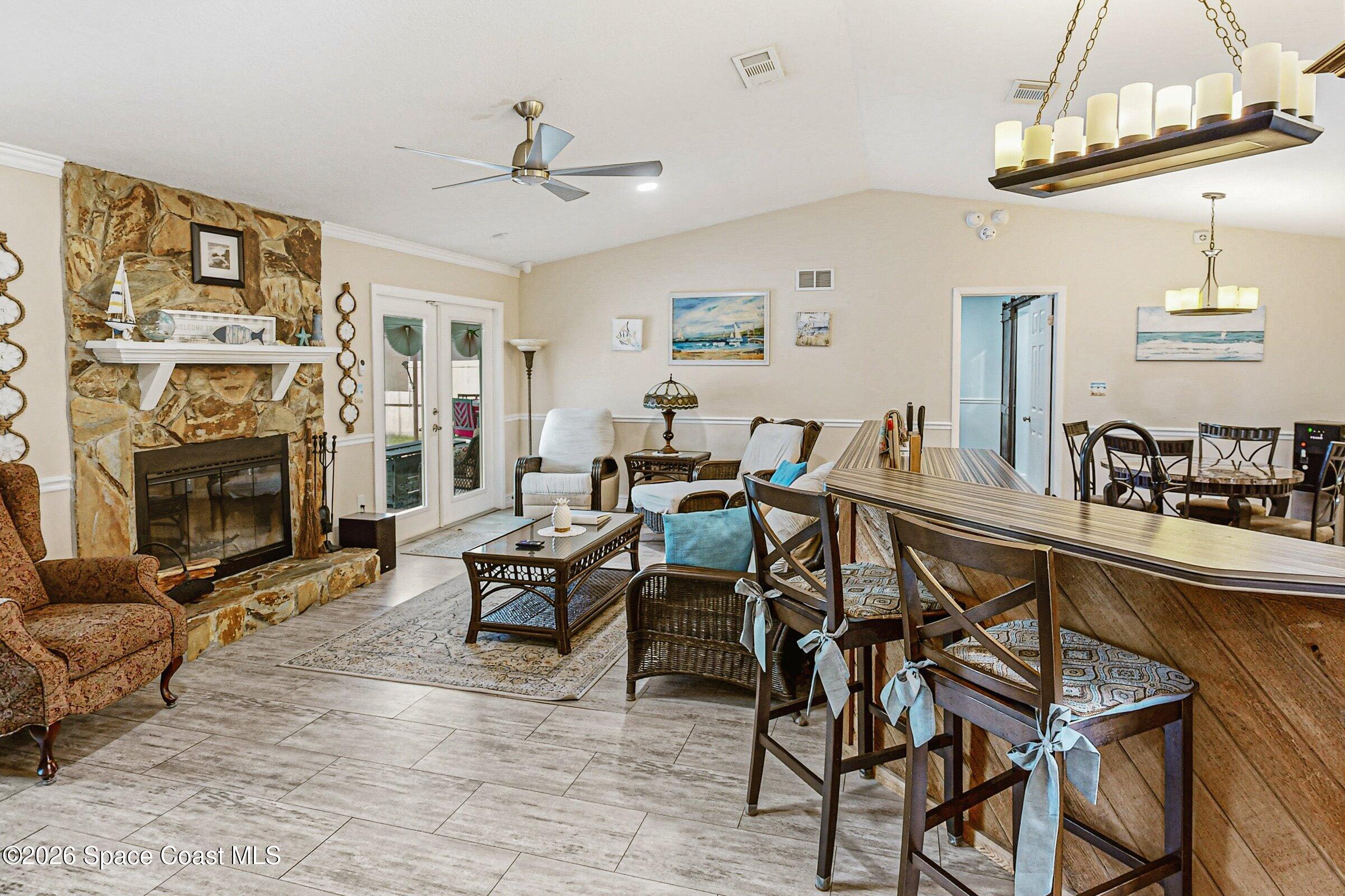 413 Orlov Road Northwest Palm Bay, FL 32907 - Photo 6 of 63 a living room with furniture a fireplace and a chandelier