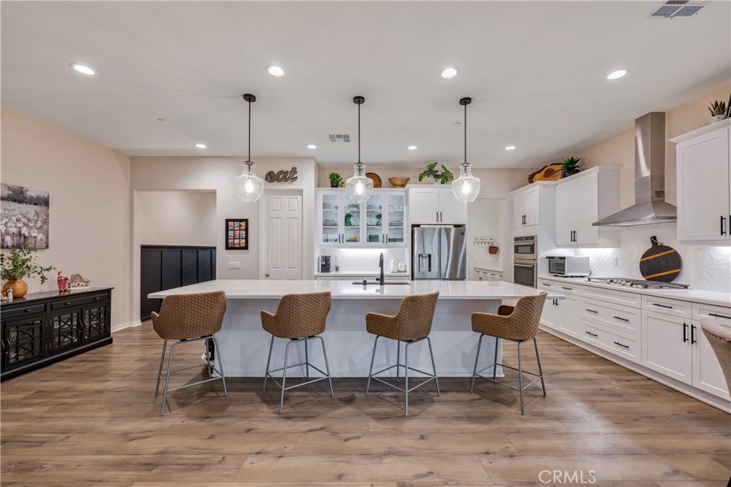a kitchen with stainless steel appliances kitchen island granite countertop a table and chairs in it