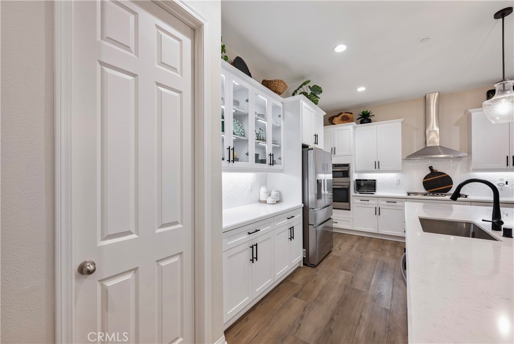 4124 Cameron Way Corona, CA 92883 - Photo 23 of 76 a large kitchen with stainless steel appliances lots of counter space and wooden floor