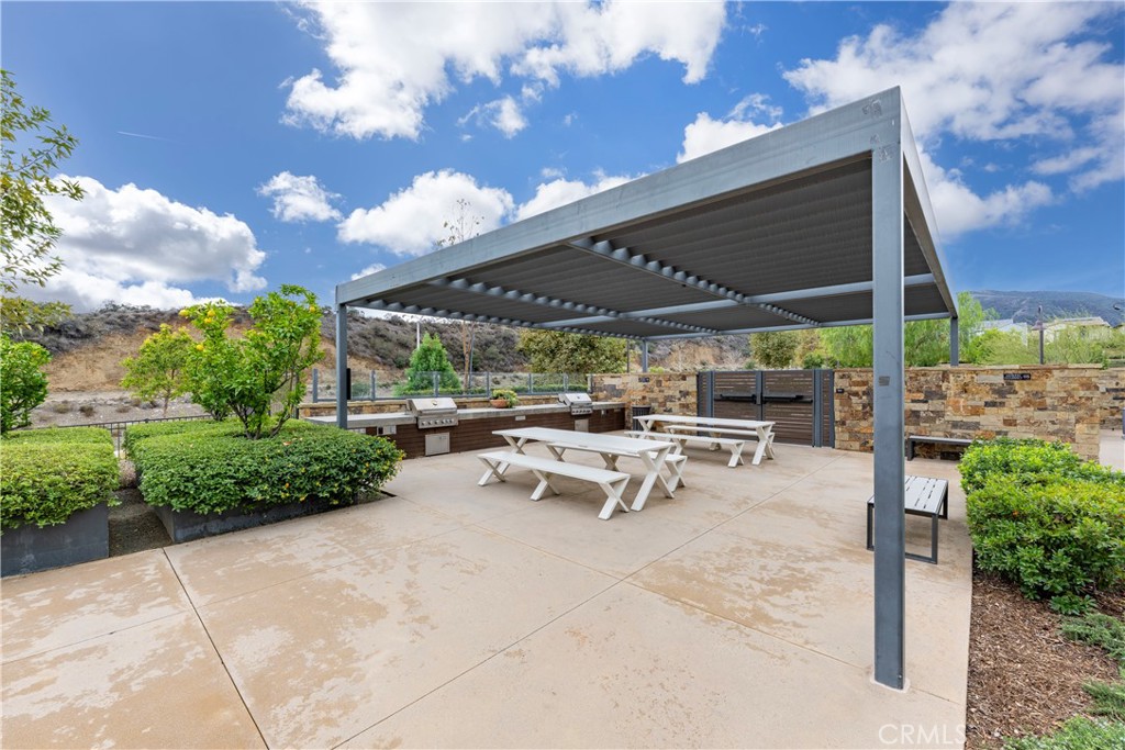 4124 Cameron Way Corona, CA 92883 - Photo 51 of 76 a view of a patio with table and chairs under an umbrella with a big yard