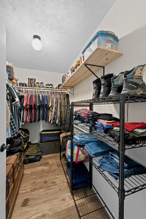 a view of walk in closet with clothes and shoes
