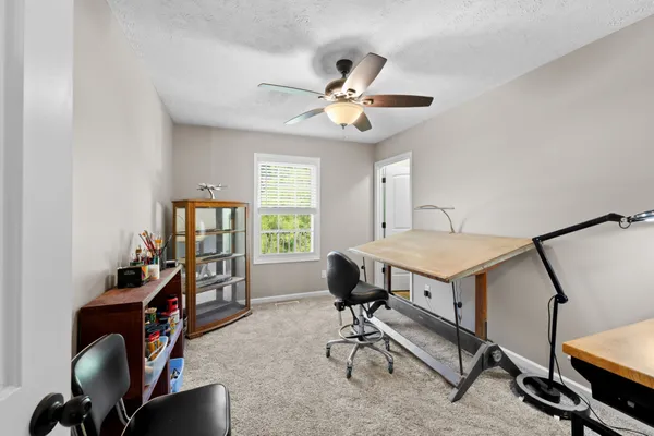 a view of a workspace with furniture and a window