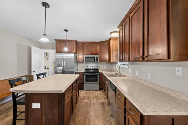a kitchen with granite countertop a sink a counter space appliances and cabinets