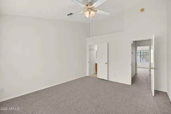 an empty room with a window and a fan