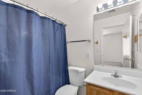 an empty room with a chandelier fan and windows