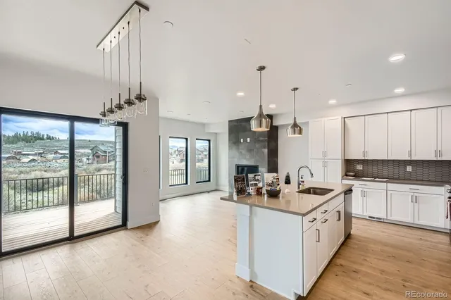 a large white kitchen with a large window appliances and cabinets