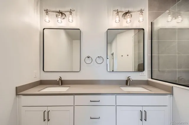 a bathroom with double vanity sinks and a mirror