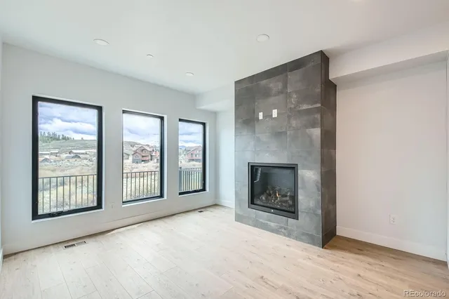 a view of an empty room with a fireplace and windows
