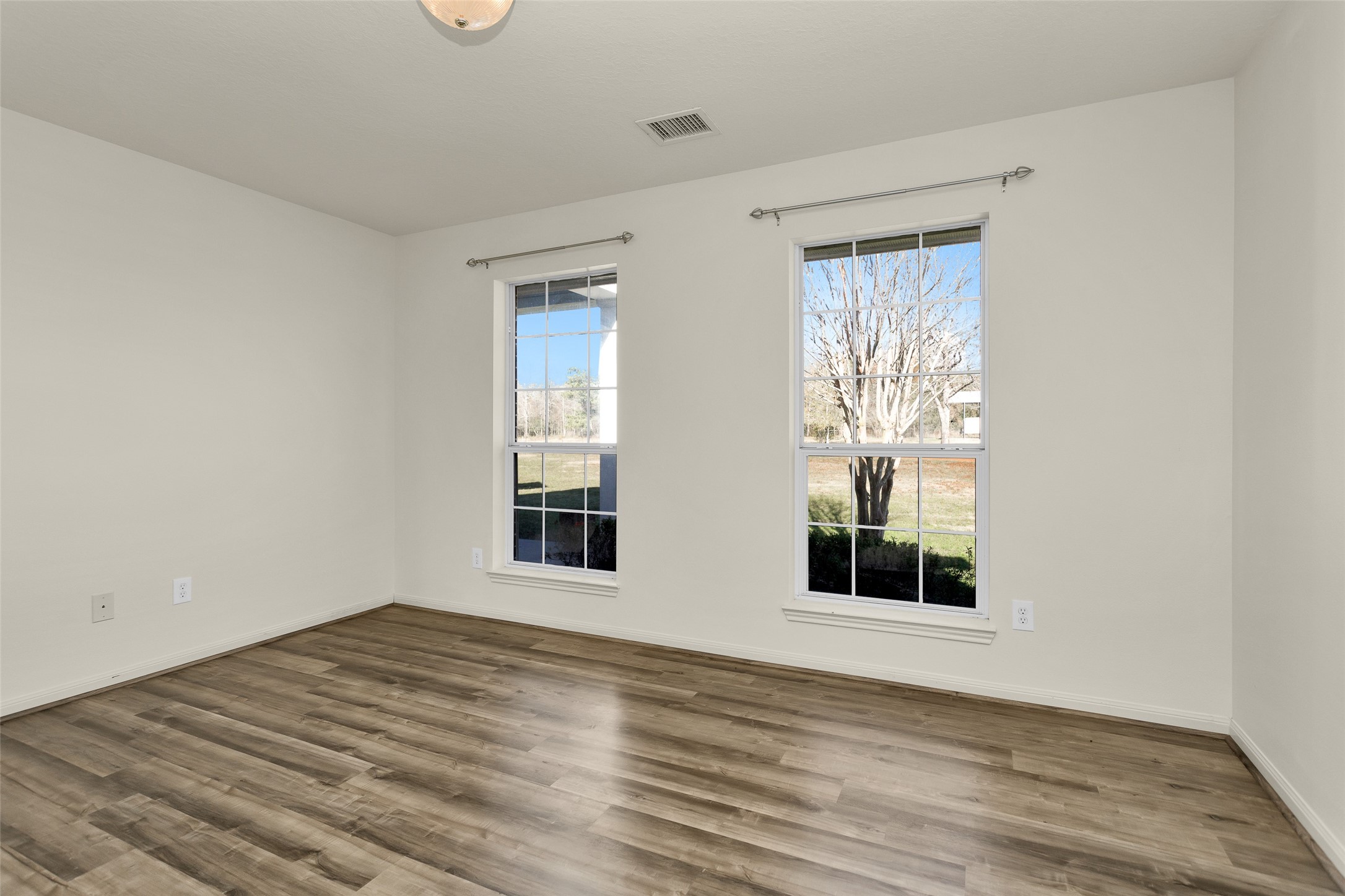 5201 Penny Road Cleveland, TX 77328 - Photo 13 of 27 a view of an empty room with wooden floor and a window