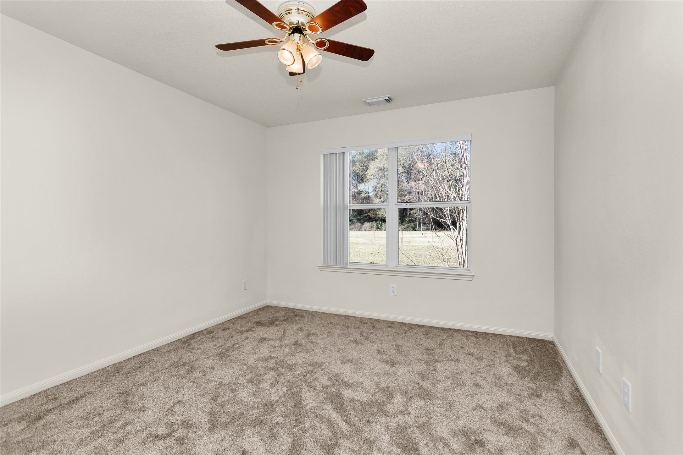 5201 Penny Road Cleveland, TX 77328 - Photo 16 of 27 an empty room with a window and a fan