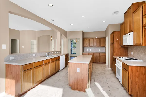 a large kitchen with stainless steel appliances granite countertop a sink and cabinets