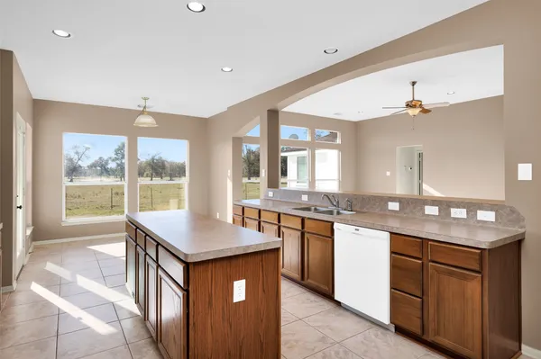 a kitchen with granite countertop a sink stove and cabinets