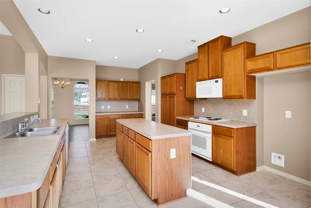 a large kitchen with stainless steel appliances granite countertop a stove a sink dishwasher and a refrigerator