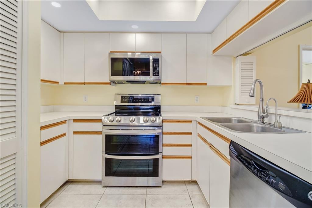 5635 Turtle Bay Drive, Unit I10 Naples, FL 34108 - Photo 11 of 25 a kitchen with a stove and a sink