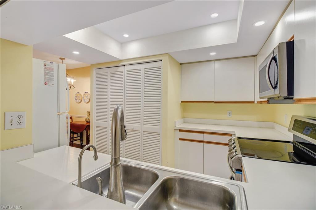 5635 Turtle Bay Drive, Unit I10 Naples, FL 34108 - Photo 13 of 25 a kitchen with stainless steel appliances granite countertop a sink and a microwave