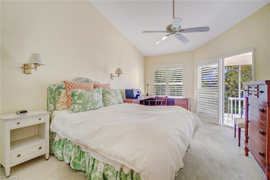 5635 Turtle Bay Drive, Unit I10 Naples, FL 34108 - Photo 14 of 25 a bedroom with a bed and a chandelier