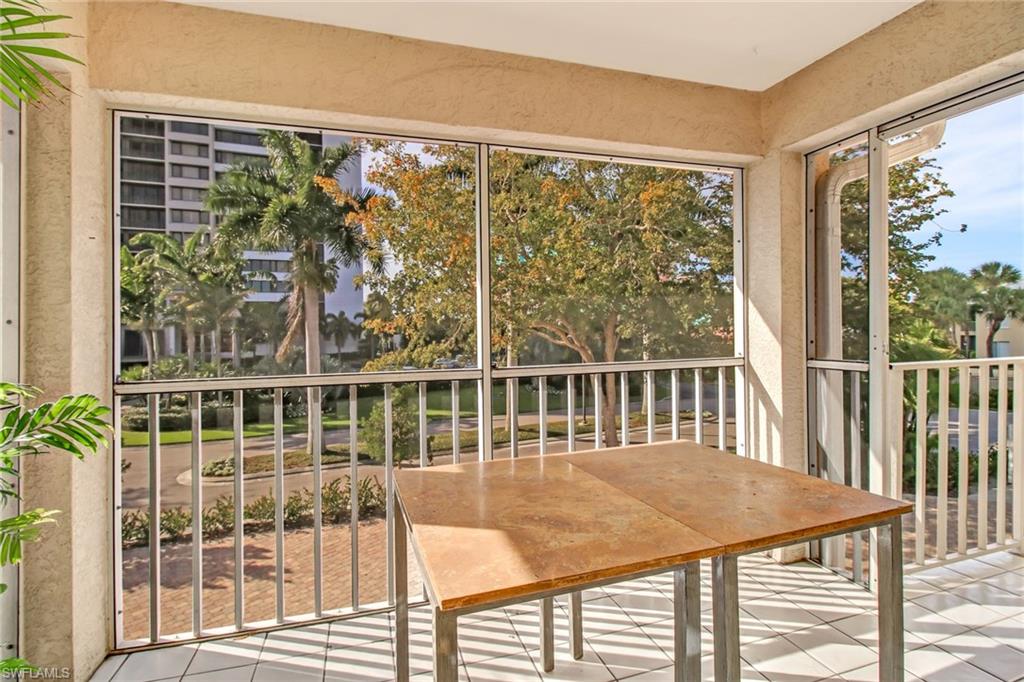 5635 Turtle Bay Drive, Unit I10 Naples, FL 34108 - Photo 21 of 25 a view of a balcony with a floor to ceiling window and wooden floor