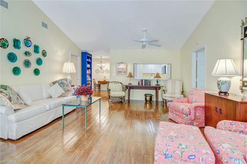 5635 Turtle Bay Drive, Unit I10 Naples, FL 34108 - Photo 5 of 25 a living room with furniture and wooden floor