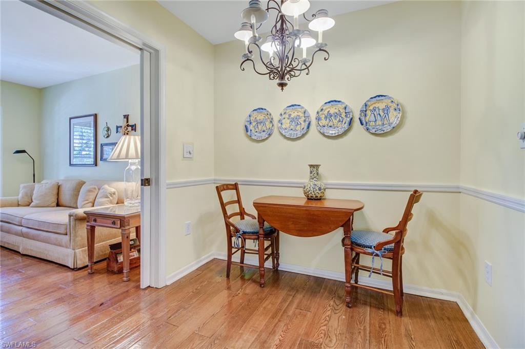 5635 Turtle Bay Drive, Unit I10 Naples, FL 34108 - Photo 9 of 25 a living room with a table and a chandelier