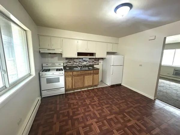 a kitchen with a stove top oven and cabinets