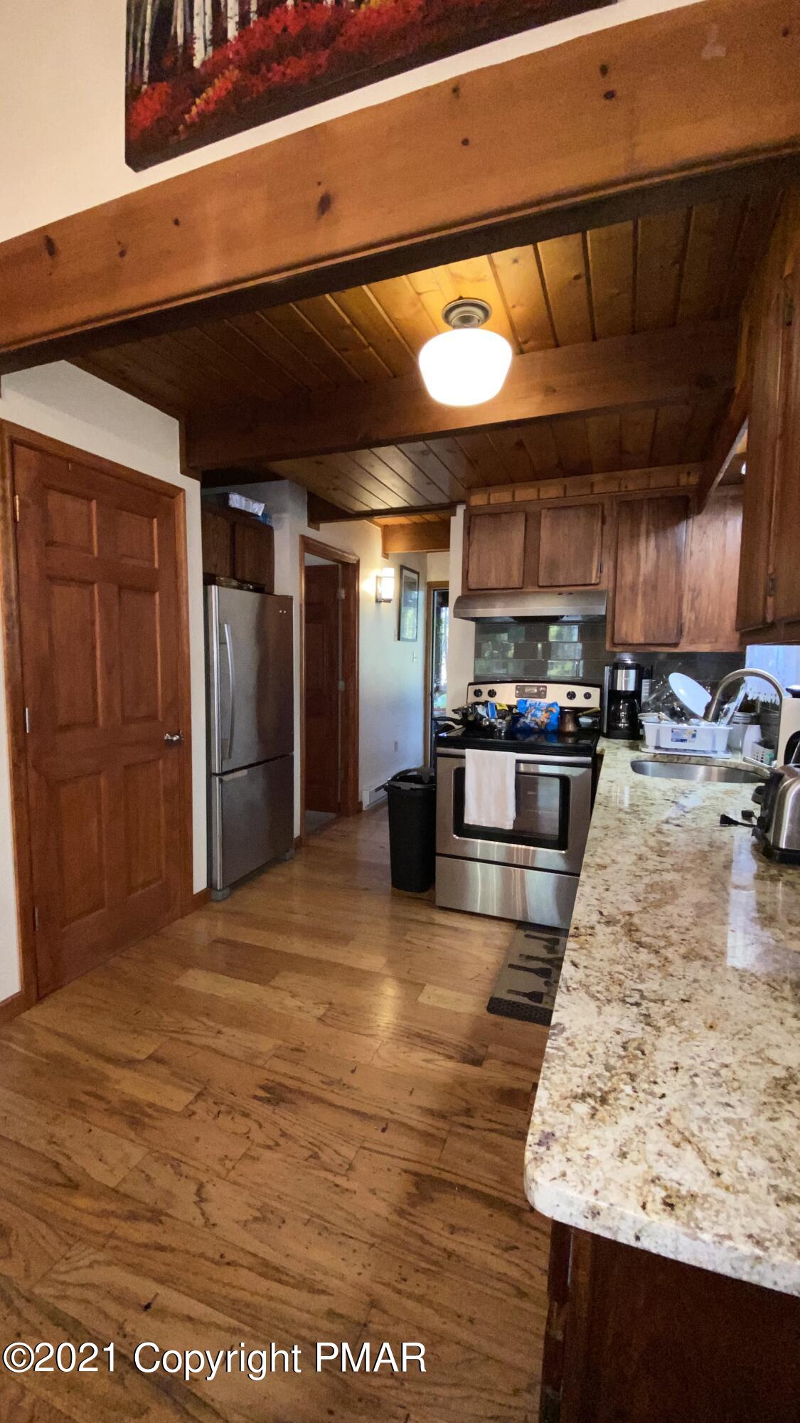 6148 Decker Road Bushkill, PA 18324 - Photo 11 of 36 a kitchen with stainless steel appliances kitchen island granite countertop a table chairs and a refrigerator