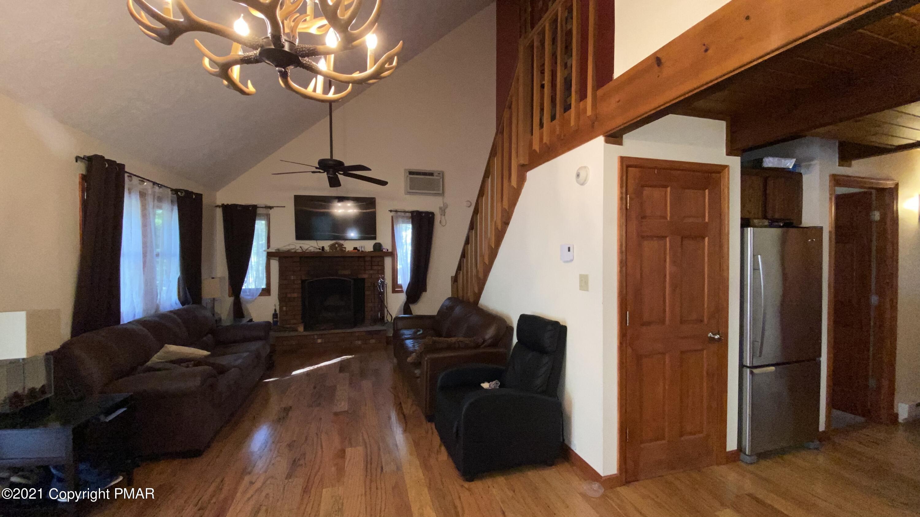 6148 Decker Road Bushkill, PA 18324 - Photo 14 of 36 a living room with fireplace furniture and a chandelier