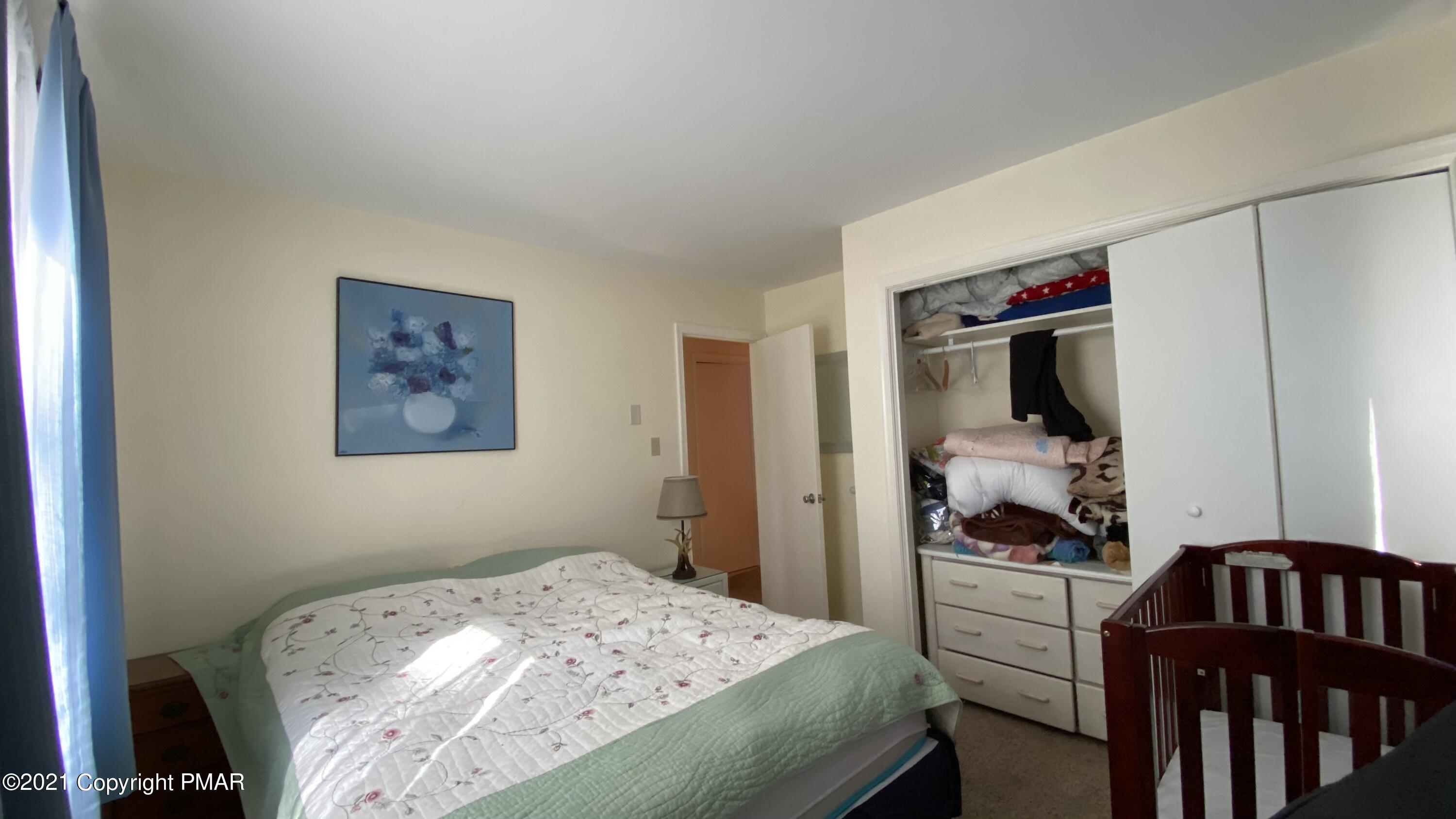 6148 Decker Road Bushkill, PA 18324 - Photo 20 of 36 a bedroom with a bed and a flat tv screen on the dresser