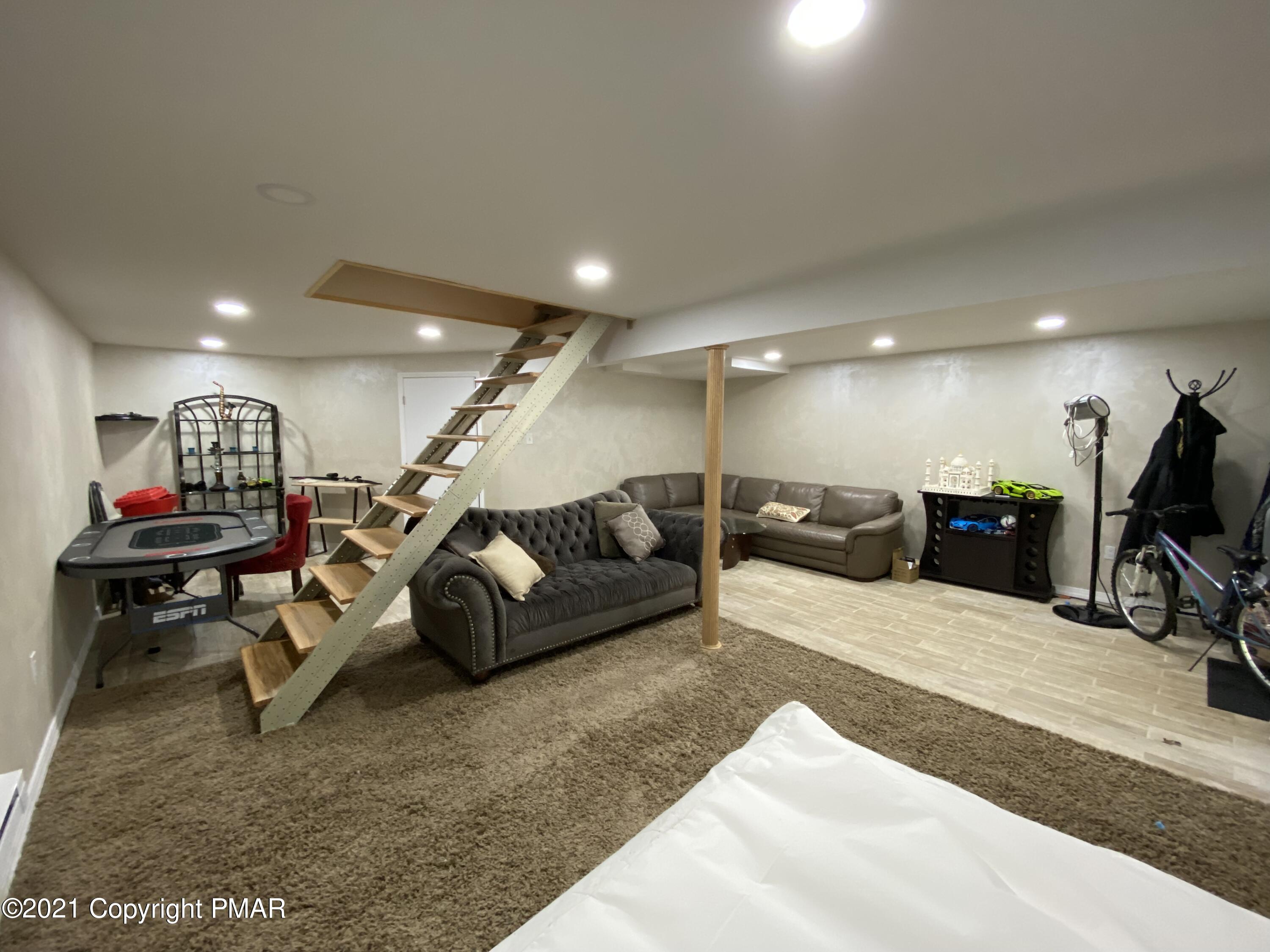 6148 Decker Road Bushkill, PA 18324 - Photo 30 of 36 a living room with furniture gym equipment and a flat screen tv