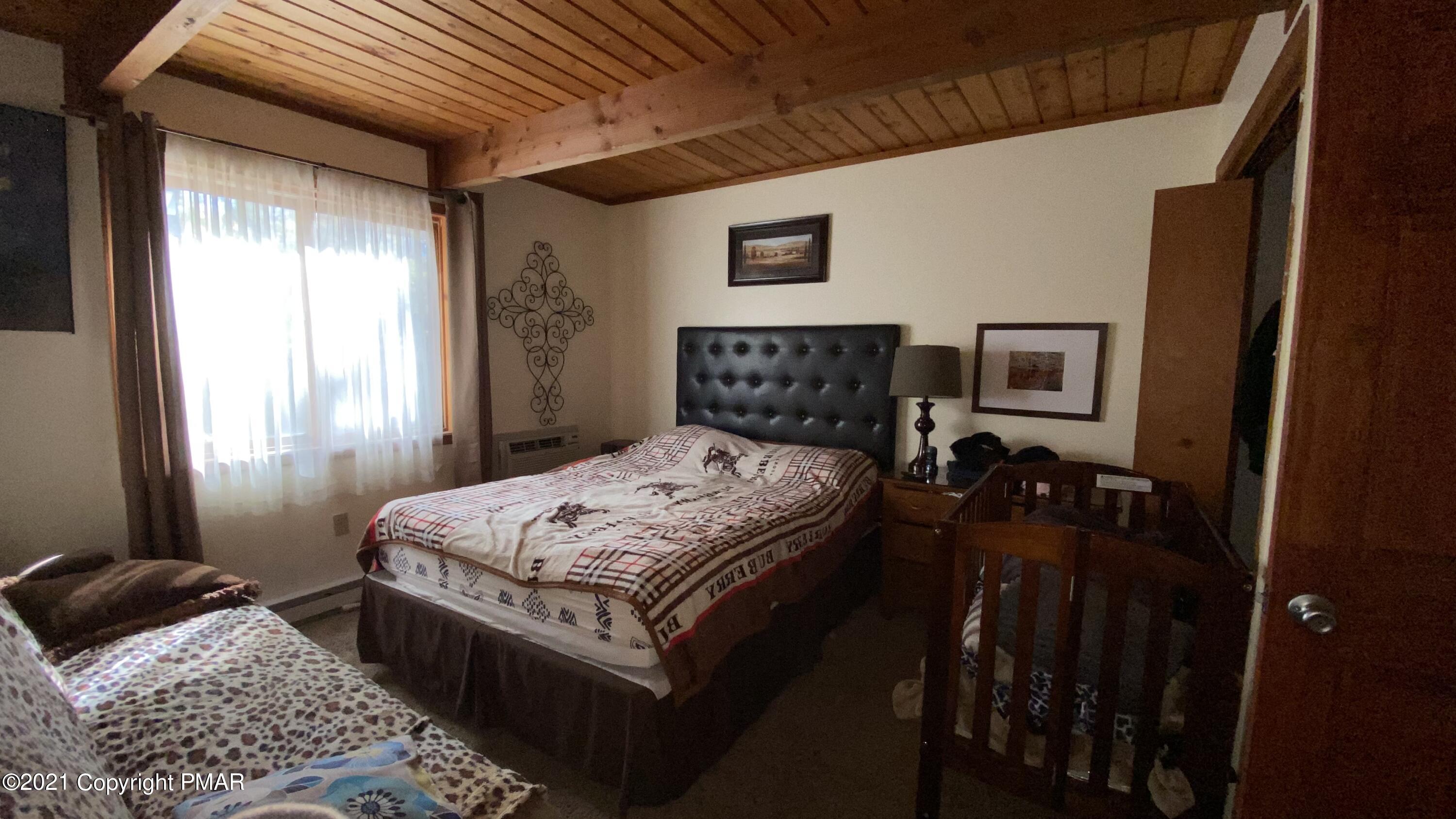 6148 Decker Road Bushkill, PA 18324 - Photo 8 of 36 a bedroom with a bed a dresser and a window