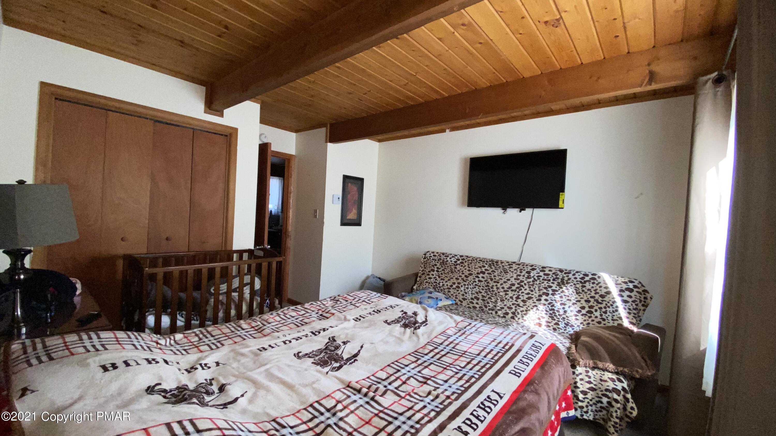 6148 Decker Road Bushkill, PA 18324 - Photo 9 of 36 a bedroom with a bed and a television