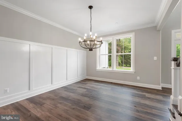 a view of a room with wooden floor chandelier and windows