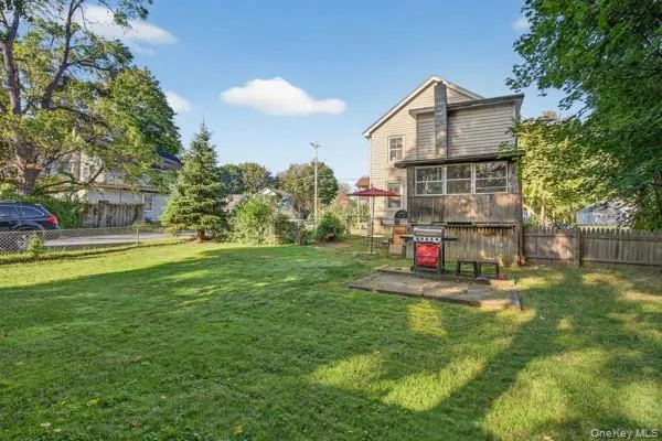 a view of a house with a big yard and large trees