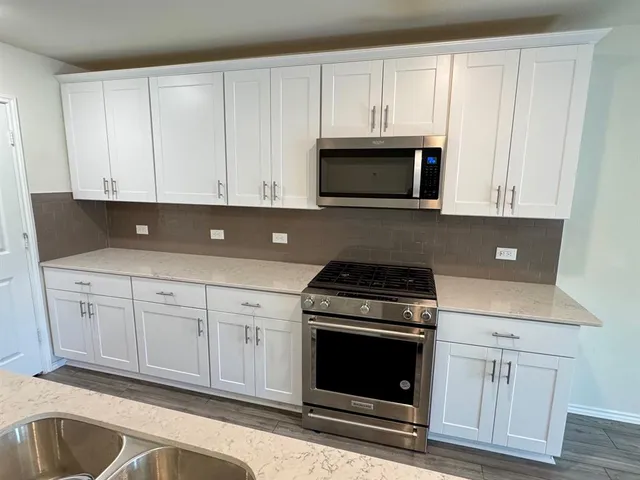 a kitchen with white cabinets and stainless steel appliances