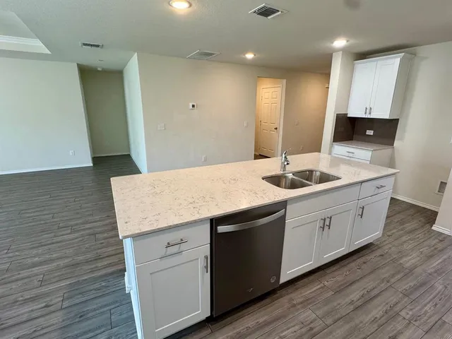 a kitchen with granite countertop white cabinets and stainless steel appliances